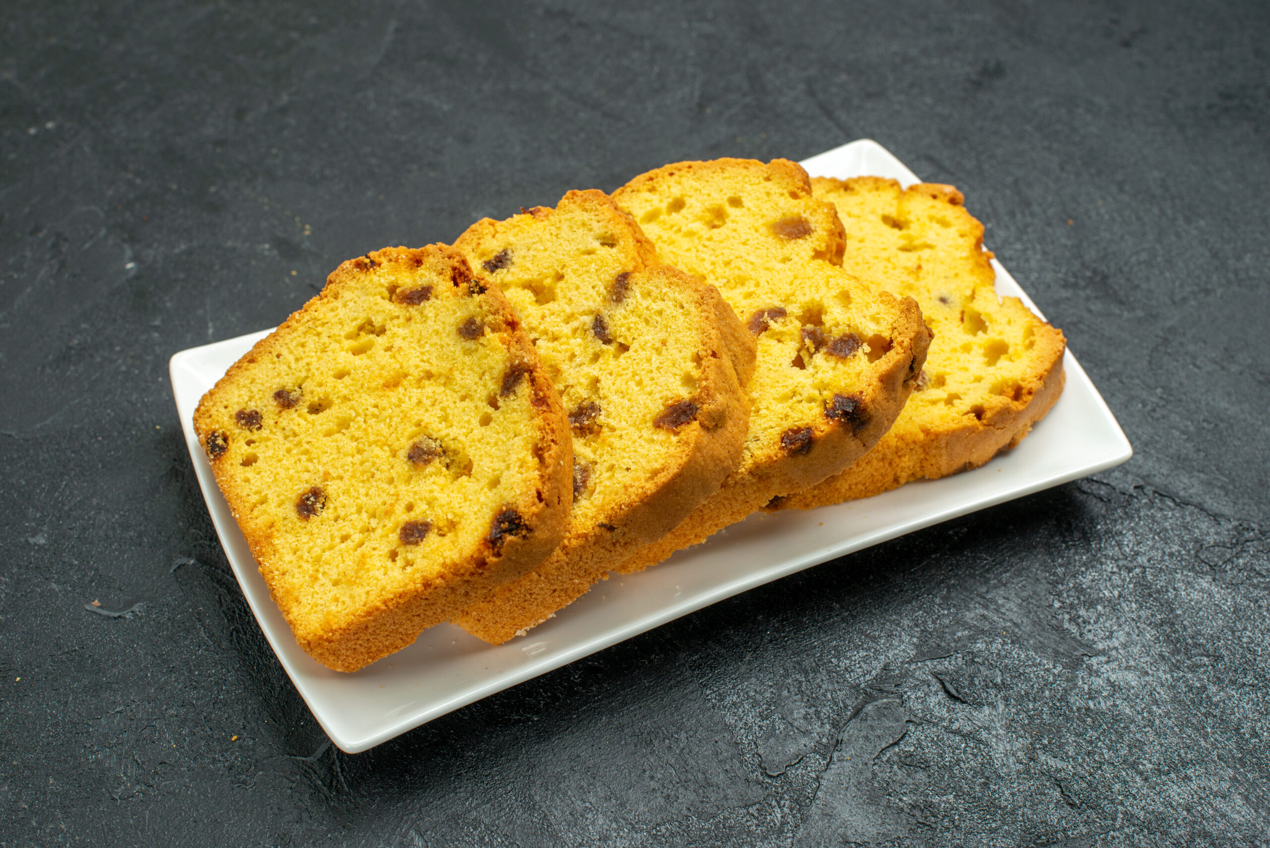 front-view-delicious-sliced-cake-inside-plate-dark-surface-sweet-cake-biscuit-tea-pie-tea